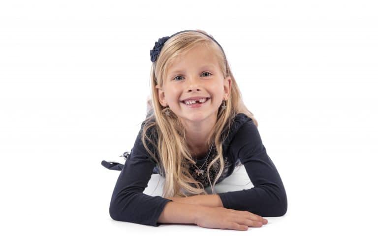 Kinderfoto van een lachend meisje op een lichte achtergrond