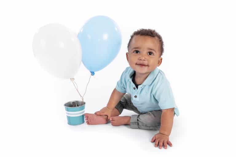 Fotoshoot van een jarig kind met ballonnen op een lichte achtergrond