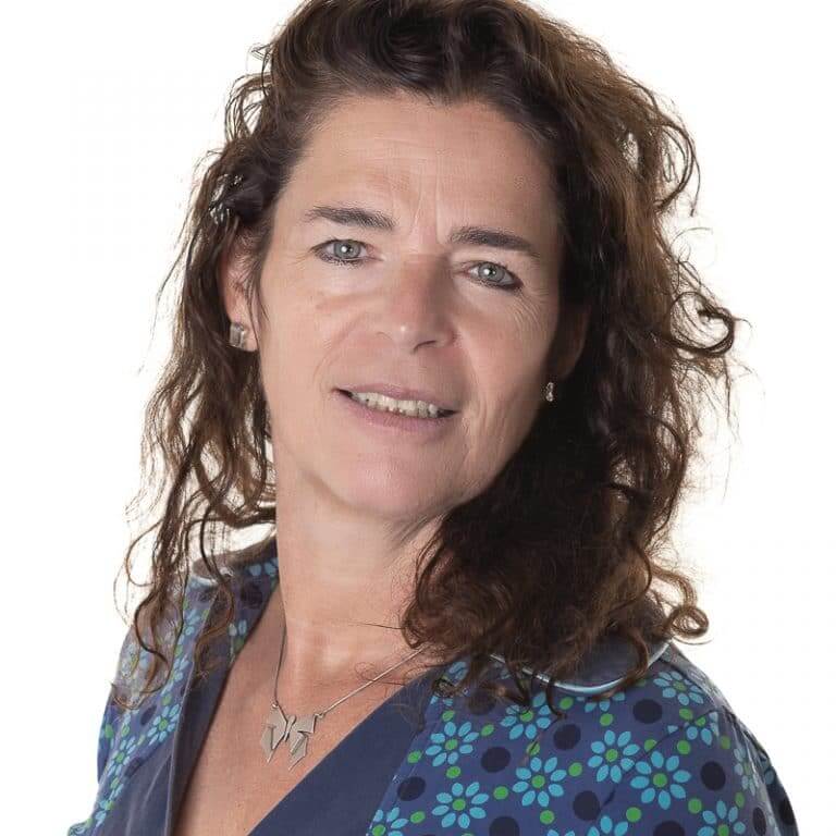 Zakelijk portret van een vrouw met krullend haar in een blauwe blouse, gemaakt in de studio in Culemborg