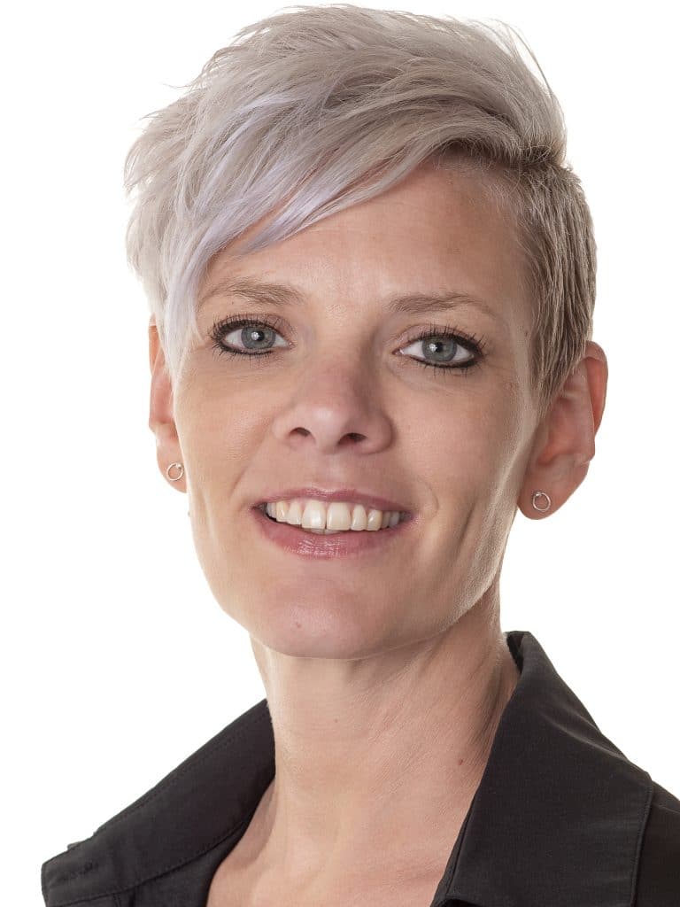 Zakelijk portret van een vrouw met kort grijs haar op een lichte achtergrond