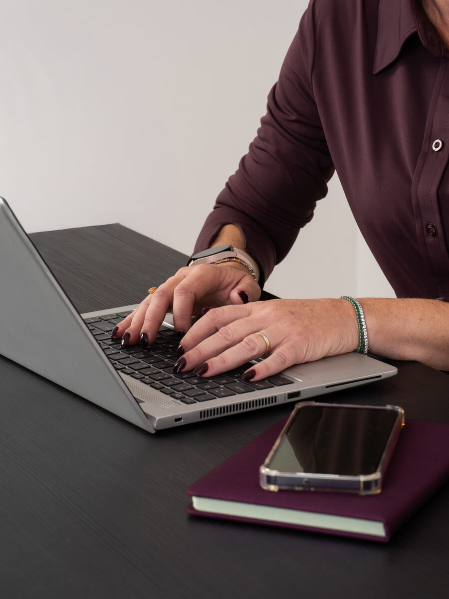 Desiree van Virtuo Office Support typend op een laptop, brandingfotoshoot bij Studio Shootable